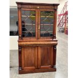 A Victorian mahogany bookcase enclosed by a pair of astragal glazed doors over frieze drawers and