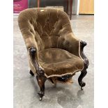 An early Victorian rosewood and upholstered tub armchair with buttoned back and scroll carved arms