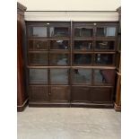 A pair of oak sectional bookcases, each in five parts enclosed by pairs of glazed doors over a
