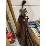 A vintage golf bag with eight hickory shafted clubs