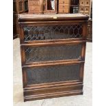 An oak Globe-Wenicke bookcase in three sections, each enclosed by a diamond pane leaded door. 45'