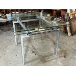 A modernist design glass topped drawleaf table and four chairs