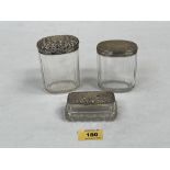 Two Victorian glass dressing table jars with silver covers. 4' high and smaller and an Edward VII