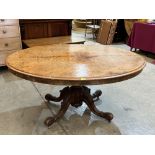 A Victorian walnut breakfast table, the oval top on carved bulbous column and quadripartite support.