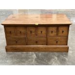 An elm chest, the lid over an arrangement of nine drawers. 44' wide