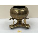 An Indian brass globular bowl engraved with wild beasts and scrolling foliage on a trefoil stand