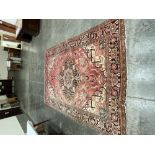 A Persian wool red ground carpet. 132' x 94'