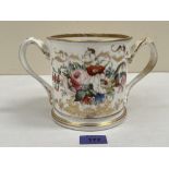 A Victorian Staffordshire loving cup, one side painted with summer flowers, the other in gilt script