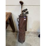 A vintage golf bag with eight hickory shafted clubs