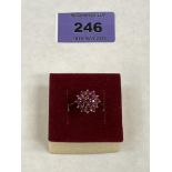 A red stone cluster ring. In gold marked 375. 3g gross. Size N