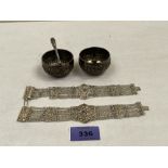 A pair of Indian silver salts with spoons and a pair of Indian filigree bracelets