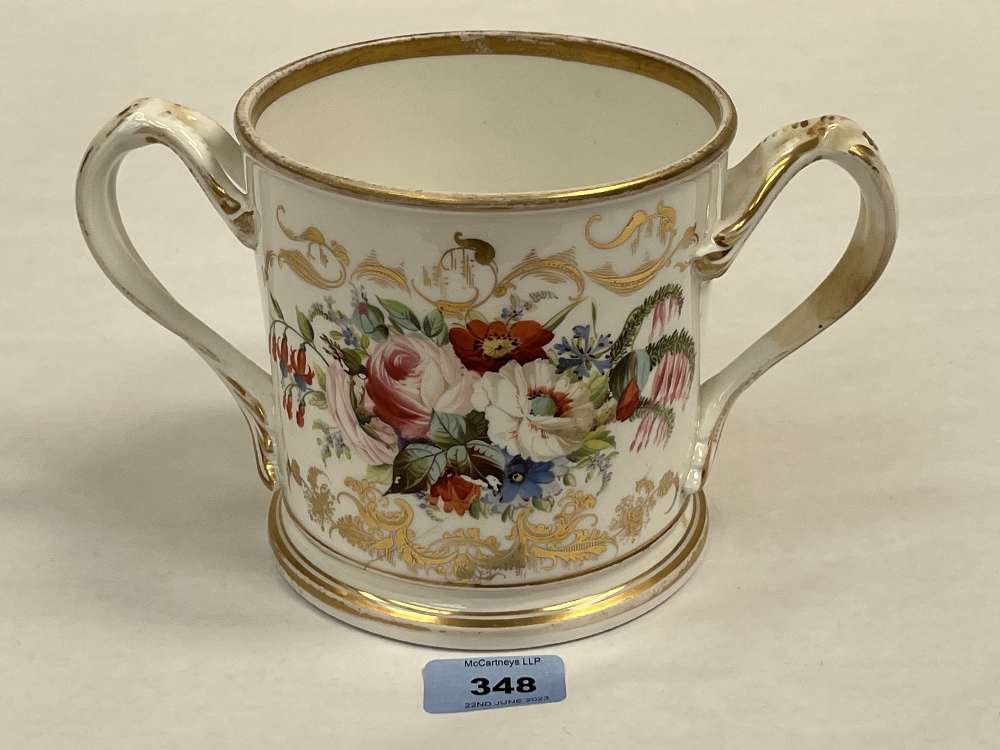 A Victorian Staffordshire loving cup, one side painted with summer flowers, the other in gilt script