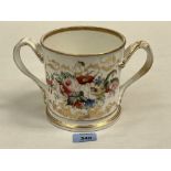 A Victorian Staffordshire loving cup, one side painted with summer flowers, the other in gilt script