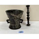 A 17th century Dutch bronze mortar and pestle with stylised dolphin handles, cast with banded