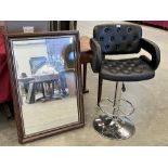 A bar stool and a wall mirror with bevelled plate