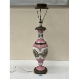 A 19th century continental table lamp, decorated with a continuous band of summer flowers on a