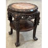 A 19th century carved hardwood pot stand with inset marble, raised on anthropomorphic legs united by