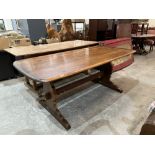 An Ercol reflectory style dining table on shaped trestle supports. 71' long