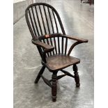 A 19th century elm child's Windsor armchair. Damage, old repairs.