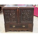 An oak cupboard enclosed by a pair of foliate carved foors over a base drawer. 46' wide