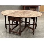 A yew wood dropleaf table on bobbin turned legs and double gateleg supports. The frieze with a