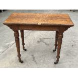 A Victorian oak card table with baize lined top on ring turned tapered legs. Bears label for