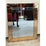 An Art-Deco wall mirror with pink glass sectional perimeter plates. 30½' x 24½'