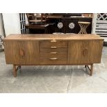 A 1970s teak and veneered sideboard. 69' wide