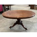 A Victorian mahogany snap-top supper table, the oval top on turned column and tripod support. 52'