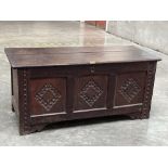 An early 18th century joined oak chest, the chip carved lid over three panel, carved front, raised