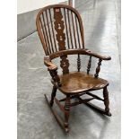 A 19th century Windsor broad arm rocking chair with elm seat