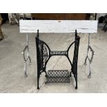A pair of cast iron bench ends and a Singer cast iron treadle base