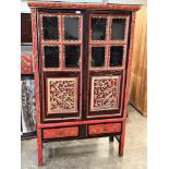 An oriental painted and gilded cupboard, enclosed by a pair of glazed doors over conforming drawers.