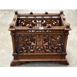 A Victorian walnut jardiniere, carved and pierced with adorsed birds, music staves and scrolled