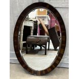 A 1920s oval wall mirror with bevelled plate