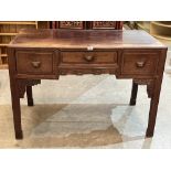 A Chinese hardwood side table with three drawers on square legs and blind fret carved brackets.