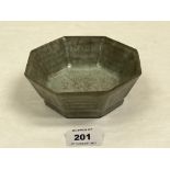 A Chinese octagonal celadon glazed bowl, the interior with sgraffito characters. 5¼' diam. Cracked