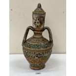 A terracotta two handled jar and cover with painted foliate banded decoration. Possibly Moroccan.