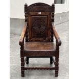 A 19th century oak panel back armchair in 17th century style