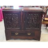 An oak cupboard enclosed by a pair of foliate carved doors over a base drawer. 46' wide