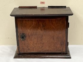 An early 18th century oak and walnut mural spice cupboard, the line inlaid door with iron