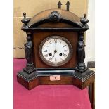 A walnut and ebonised cased mantle clock with French drum movement. 11' high.