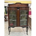 An Edward VII mahogany and inlaid display cabinet enclosed by a pair of leaded glazed doors, on