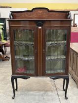 An Edward VII mahogany and inlaid display cabinet enclosed by a pair of leaded glazed doors, on