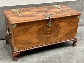 An Anglo-Rhodesian walnut chest with brass strap hinges, side handles and lock hasp, on ball and