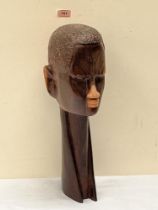 An East African lignum vitae carved male head with extended neck. 20' high, Kenyan