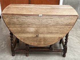 An oak drop leaf table on barleytwist legs. 41' wide