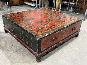 A Chinese red and black lacquer low table, gilded and decorated with dragons; ho-ho birds; flaming