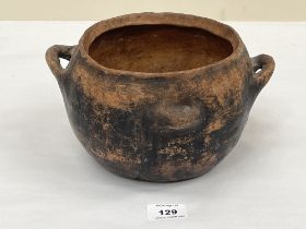 A clay two handled cooking vessel. 9½" diam over handles.