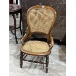 A Victorian side chair with caned balloon back and seat. Back repaired.